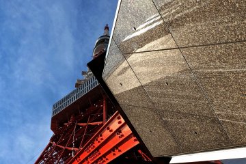 <p>站在塔脚与一座大楼之间仰拍的东京铁塔。</p>