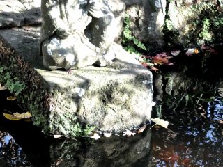 A statue sitting in the temple&#39;s small pond, with dusk coming soon