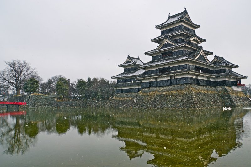 Snow covered roof tops (and two swans!) at Matsumoto Castle. One of four National Treasures in Japan.