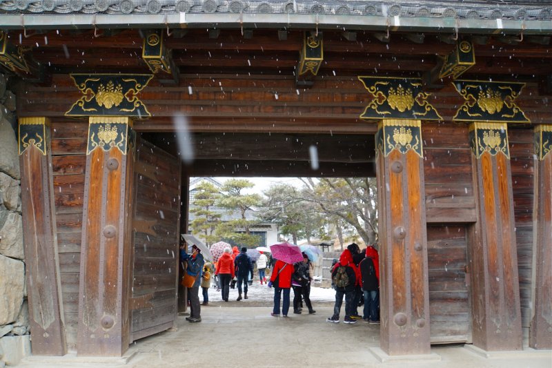 Visitors at the main entrance embrace the snowfall by holding umbrellas