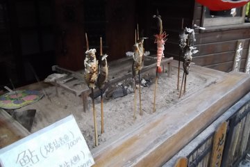 <p>There are lots of places to buy snacks, like barbequed fish on a stick</p>