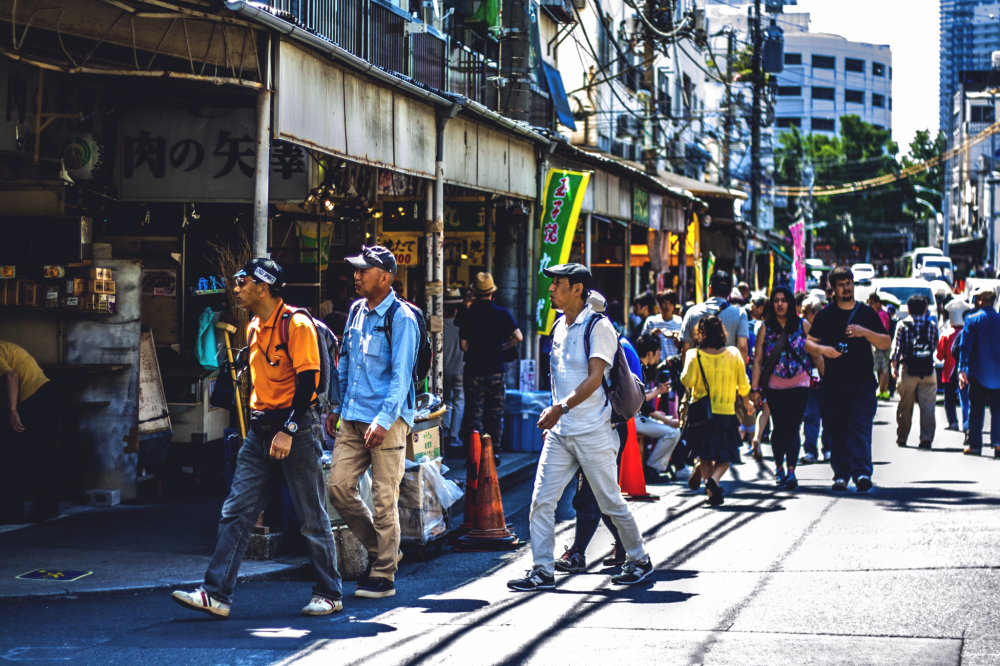 Touristes &eacute;trangers et Japonais se croisent dans les petites rues autour du march&eacute; de Tsukiji, venus go&ucirc;ter aux fruits de mer et poissons du jour