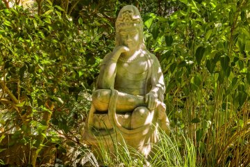 <p>A statue of Gautama Buddha (Shaka Nyorai), sits within Hokokuji&#39;s peaceful stone garden</p>