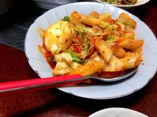 Чтобы завершить трапезу - блюдо токпокки. Токпокки - это смесь моти в корейском стиле (в форме цилиндров) с овощами в остро-сладком соусе с богатым вкусом.