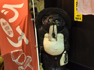 Một con chồn tanuki dễ thương chào mừng bạn ở cổng vào!