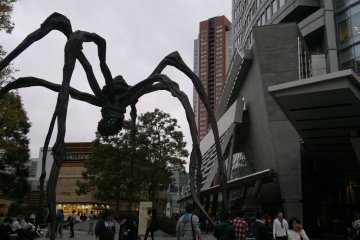 <p>Statue of Maman and Mori Tower during the day.</p>