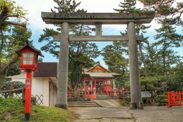 <p>The main building of the shrine, framed by a stone gate</p>