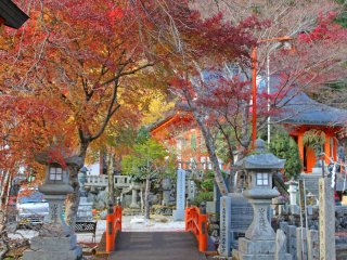 The stone lanterns and fiery leaves form a beautiful gateway over one of the entrance bridges
