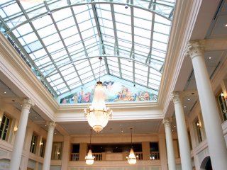 Brilliant lights are coming through the glass ceiling into the hotel lobby
