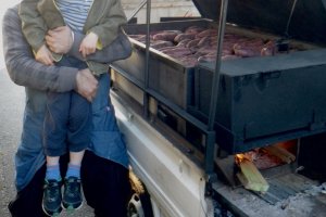 Memeriksa ubi yang ada di bawah tutup oven di bagian belakang truk mini.
