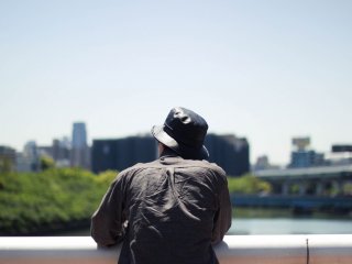 Một người đàn ông đang lặng lẽ ngắm nhìn cảnh vật từ trên cầu