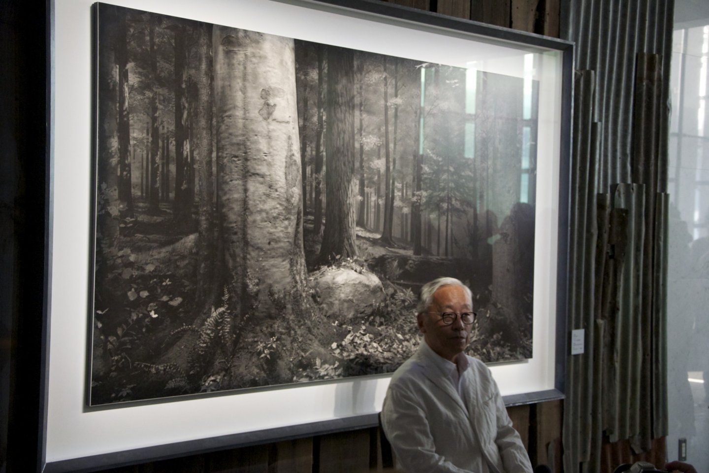 Hiroshi Sugimoto standing in front of one of his images