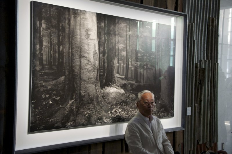Hiroshi Sugimoto parado frente a una de sus imágenes 