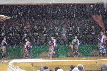 The stage is outside at a shrine. Audience members must also endure the cold weather.