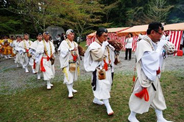 In formation, blowing the conch shell, yamabushi are entering the sacred bonfire place