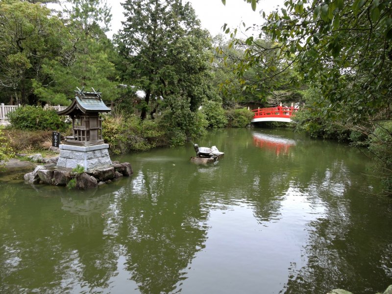 Pond with red bridge, stone turtle and small island shrine