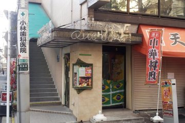 Street view of Que Bom--restaurant is down the stairs