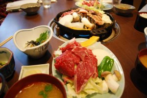 A portion of lamb meat, some veggies, rice, miso soup and pickles make for a hearty meal