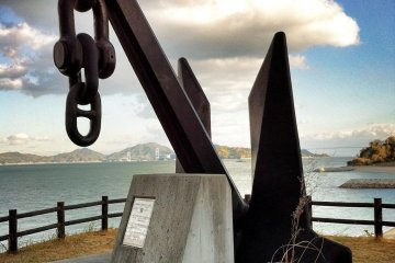 A giant anchor with the Kurushima Straits bridge in the background