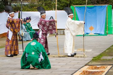 Preparing to begin the hassetsu, or 8 stages of shooting; the man in green is an attendant
