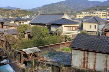 Behind the main street is a maze of alleyways with fine views over Honai. In the foreground, an old lady pumps water from a well.