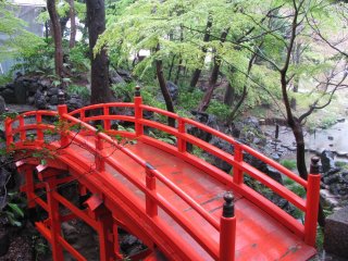 Jembatan berwarna merah merupakan elemen tradisional taman bergaya Jepang