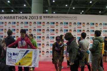 Runners posing at the sponsors board after the race
