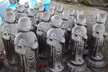 Lots of little statues attending around a larger one.
