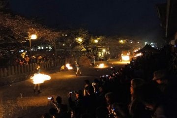 A host of fiery torches on the path in front of Aso Shrine
