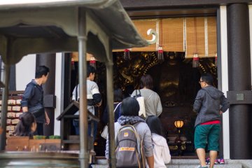 Visitors ascend the steps to the Amida-do hall to pray for protection from evil
