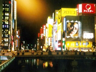 The neon lights are reflected on the river at Osaka&#39;s heartbeat Dotonbori. During the World Cup, fans would jump into the river to celebrate when their team won. See Japan at play in this unihibited place of fun.
