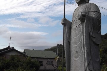 A Buddhist statue at the roadside by the hill