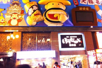 Oversized Cartoon Characters like Popcorn man lure us into a night fantasy that is adult and childlike at the same time at Dotobori
