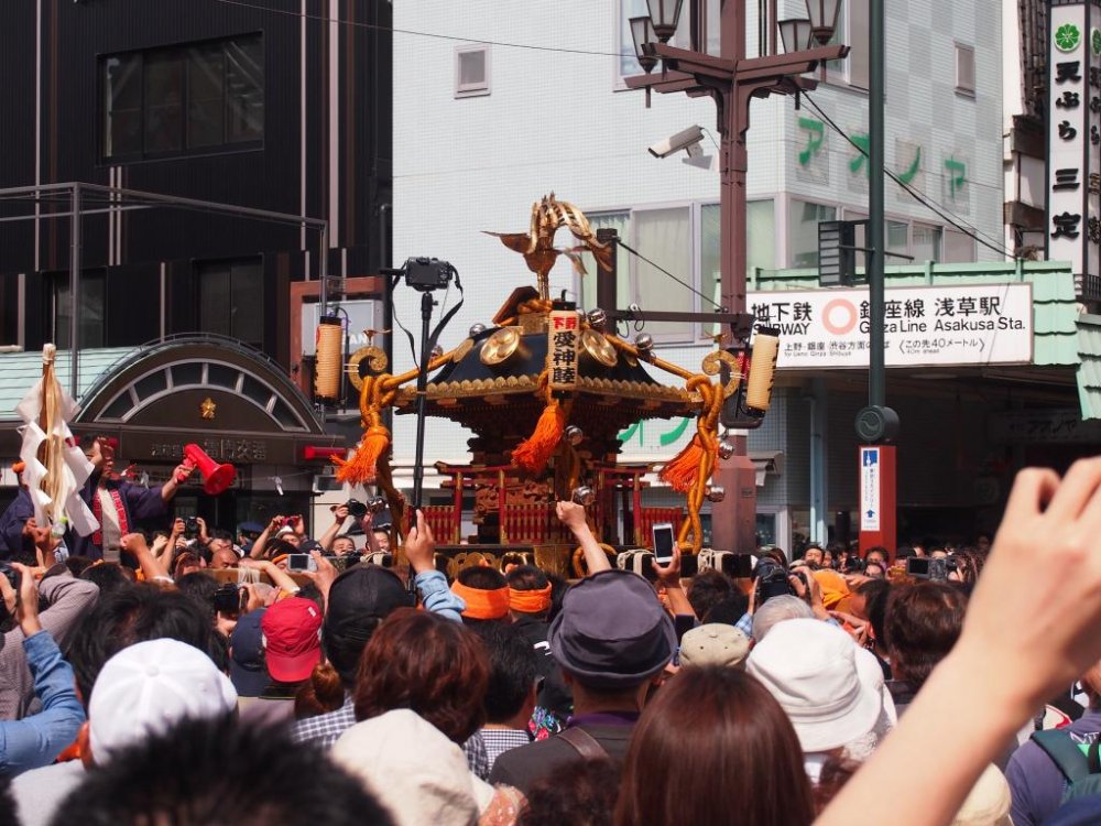 The mikoshi being borne around the streets that have been temporarily blocked off for the day. The subways still work, though. Get off at Asakusa Station on the Ginza line and follow the crowd out. You can&#39;t miss it.