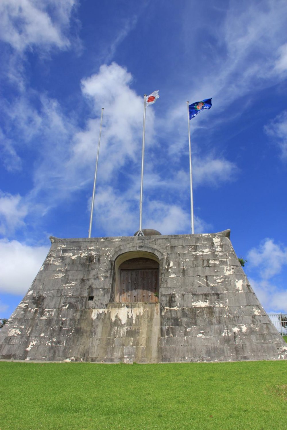Tiang-tiang bendera stadion berada di atas sebuah gerbang batu yang terinspirasi dari Situs Warisan Dunia Sonohyan Utaki yang ada di Naha