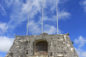 The stadium's flag poles rest upon a stone gate inspired by the Sonohyan Utaki UNESCO World Heritage Site in Naha