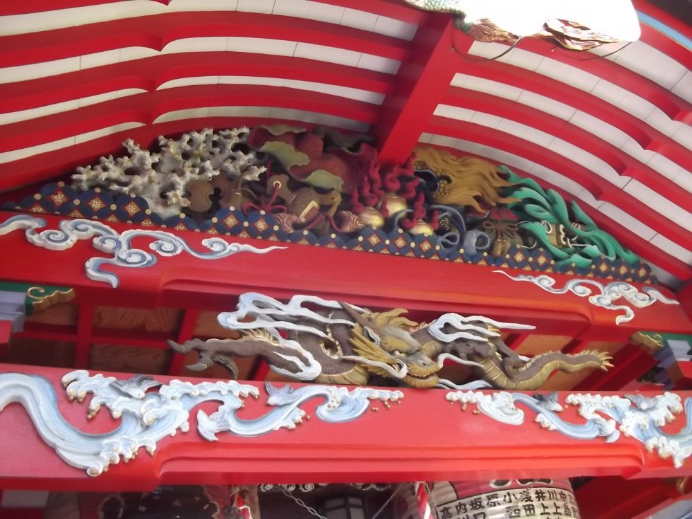 Brightly painted carvings under the eaves of the prayer hall