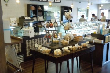 Baked packaged goods, and behind glass at the counter, cakes, pies, puddings and ice cream
