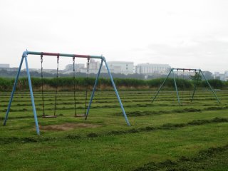 A swing set next to the trail in Tamagawa Rokugo-bashi Park