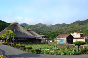 <p>The quiet and peaceful museum surrounded by fields and mountains. In the distance a yamase makes it way across the forest, carried from the sea in the distance.</p>