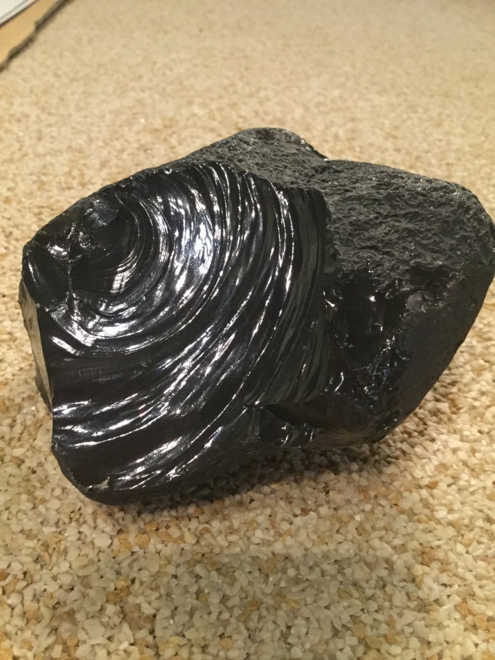 Obsidian. The edge is sharp enough to cut clean through a newspaper. Some of the earliest tools were made of obsidian.