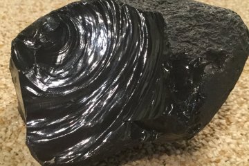 Obsidian. The edge is sharp enough to cut clean through a newspaper. Some of the earliest tools were made of obsidian.