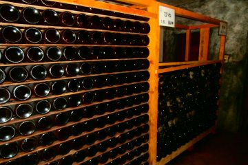 <p>Numerous wine bottles stored in the naturally-cold cellar</p>