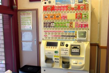 A ticket machine where you choose your meal and to pay