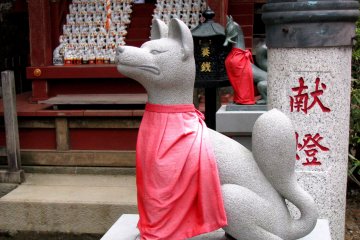 Kitsune with red apron at Takao-san shrine