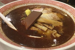 Ramen topped with a dash of cocoa oil, ginger, and a chocolate bar.