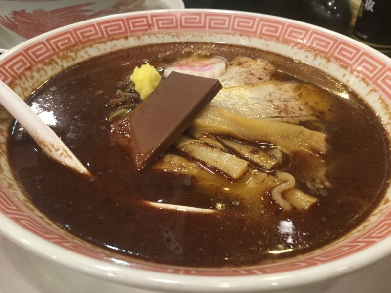 Ramen topped with a dash of cocoa oil, ginger, and a chocolate bar.