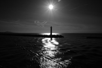 A black & white photo of a lighthouse from the ferry