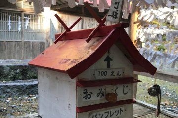 A cute little lucky charm hut in the shape of a shrine building.