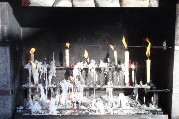 Candles burning at a shrine at Fushimi Inari.